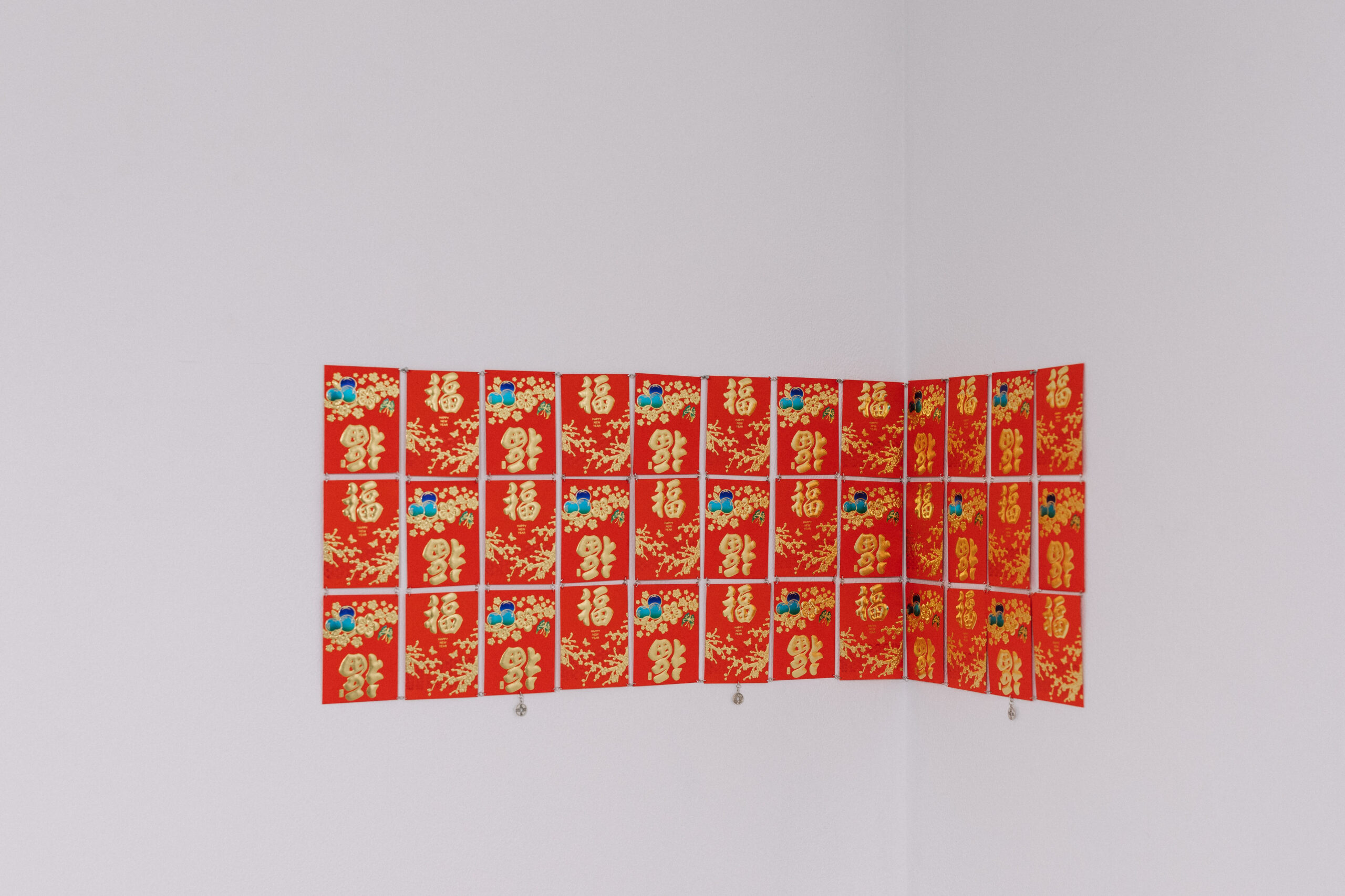 Installation documentation of a 3x 12 grid of paper Hong Bao.