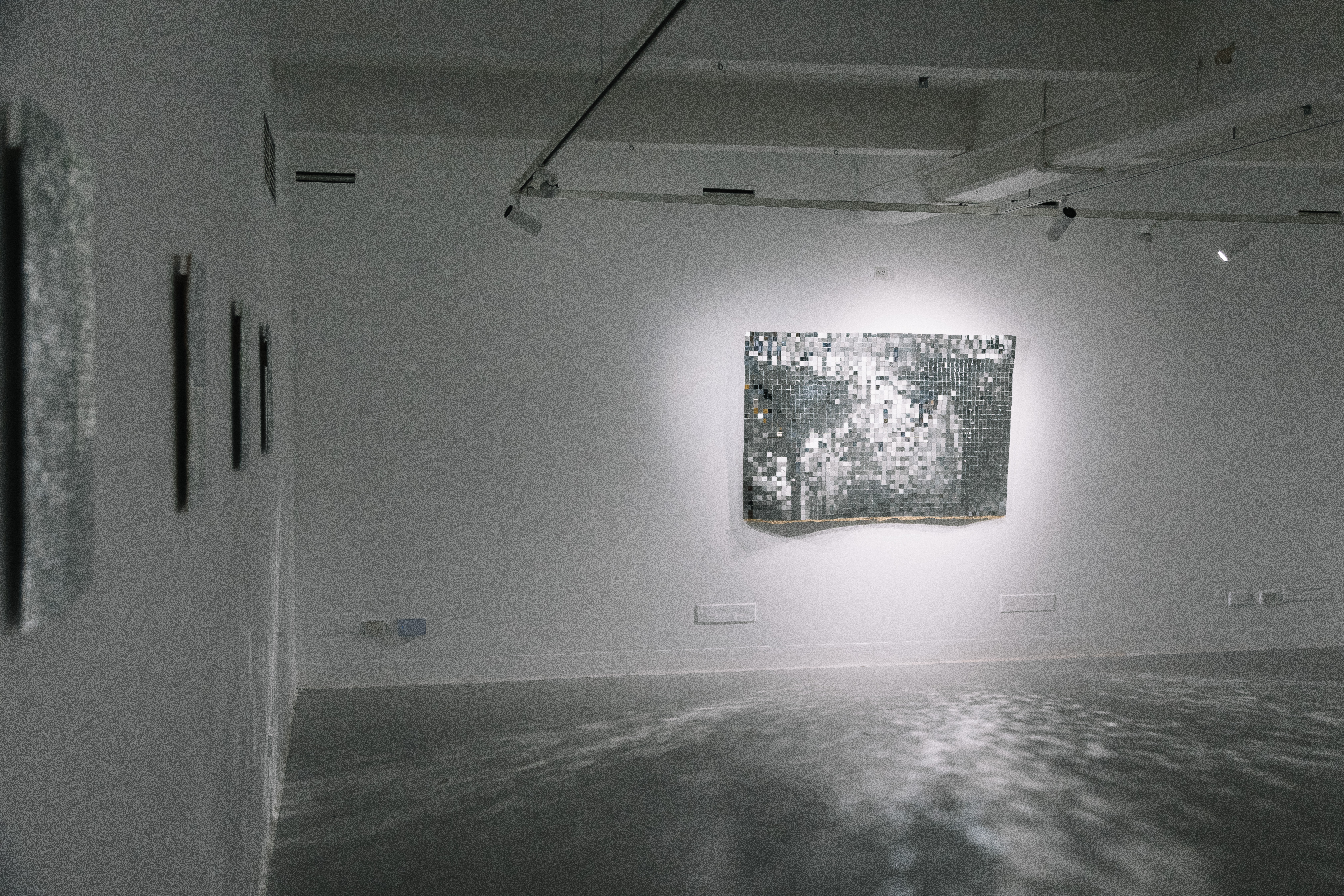 A detailed photograph of mirrored artworks installed on a wall