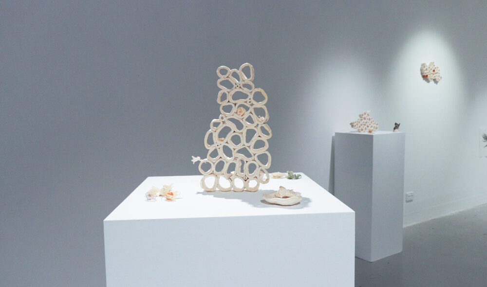 A photograph inside an art gallery of small ceramic sculptures on plinths